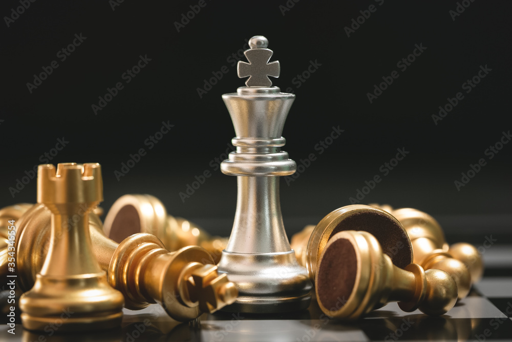 Human hand moving dark King chess piece at table