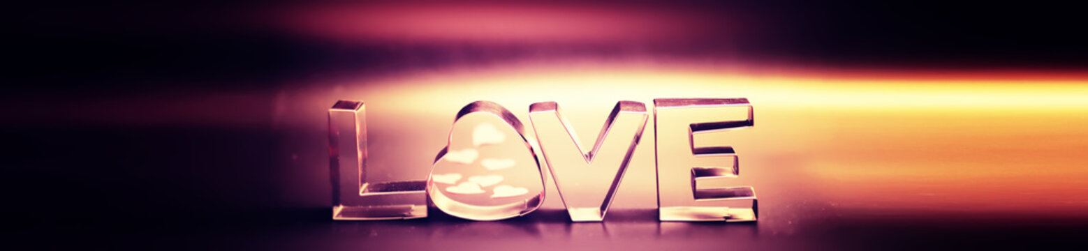 Wooden and metal letters forming word LOVE written on dark black background with lights.