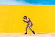 © VISTA by Westend61 - Young man dancing in front of yellow wall, taking selfies