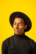 © VISTA by Westend61 - Portrait of young man, wearing black in front of yellow wall, eyes closed