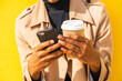 © VISTA by Westend61 - Young man with coffee cup, using smartphone