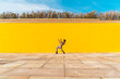 © VISTA by Westend61 - Young man dancing in front of yellow wall
