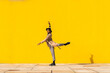 © VISTA by Westend61 - Young man dancing in front of yellow wall