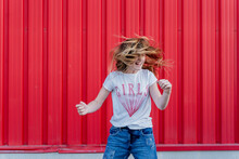 Girl Headbanging In Front Of Red Wall