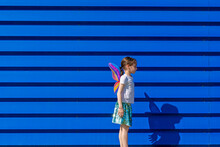 Little Girl With Colourful Butterfly Wings In Front Of Blue Background
