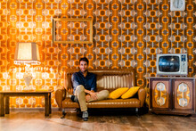 Man Sitting On Couch In Vintage Living Room