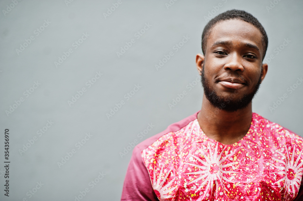 Portrait of a black young man wearing african traditional red colorful clothes. - obrazy, fototapety, plakaty 
