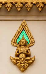 Detail of a praying buddha image on a temple wall at a religious site in Siamese Lao PDR, Southeast Asia