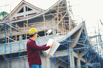 Engineering, the people on the construction site are holding a blueprint in their hands, building inspector, inspect the construction site and business plan of the new building.