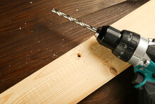Screwdriver With Drill On Wooden Table With Drilled Wood Plank Flat Lay With Copy Space