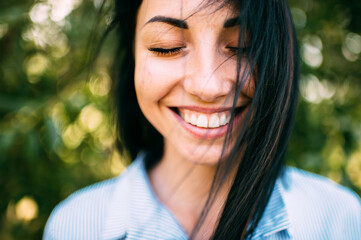 Portrait of beautiful girl with big eyes, long dark hair and pretty smile on the green background