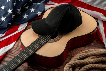 Fototapete - Freedom and american country and blues music festival concept with USA flag and acoustic guitar with a black cap on top and cowboy lasso placed on a dark wood vintage table