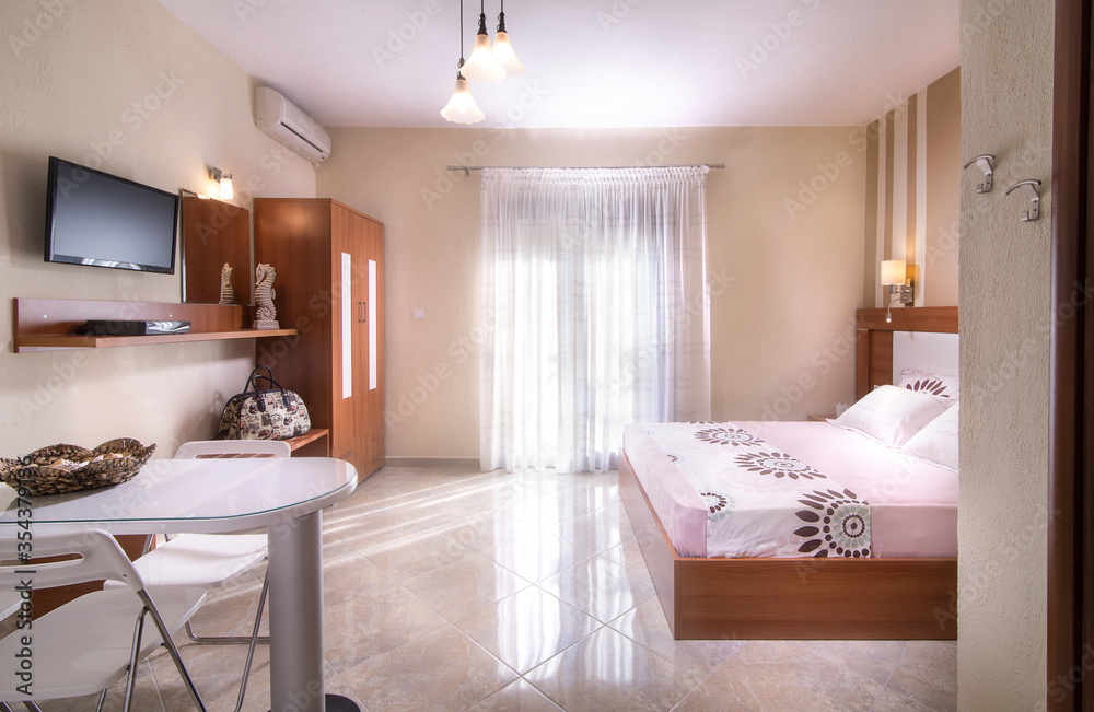 Romantic style interior of simple modern design bedroom with wooden furniture in white and beige apartment hotel room