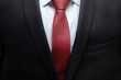 © Adil - Closeup of black business suit with white shirt and red tie. Businessman in a black suit with a red tie. Business concept.