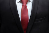Fototapeta Tęcza - Closeup of black business suit with white shirt and red tie. Businessman in a black suit with a red tie. Business concept.