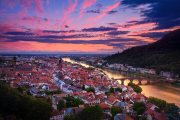 Wall Mural - Romantic aerial view of Heidelberg with Neckar river, Germany, a dramatic afterglow with vibrant red and purple colors after sunset