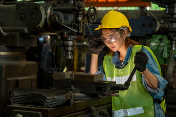 Poster - Female technician wearing hard hat and uniform are controlling the machines in the factory.