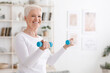 © Prostock-studio - Cheerful senior woman exercising with dumbbells at home, enjoying active healthy lifestyle