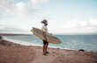 © SB Arts Media - Portrait of Hipster Surfer with dreadlocks and beard looking at the ocean with vintage surfboard .
