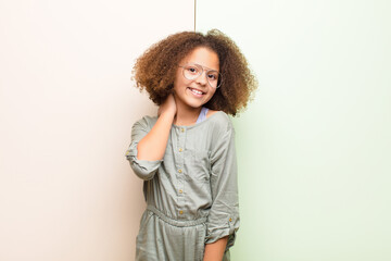 Wall Mural - african american little girl laughing cheerfully and confidently with a casual, happy, friendly smile against flat wall