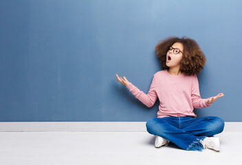 Wall Mural - african american little girl performing opera or singing at a concert or show, feeling romantic, artistic and passionate sitting on the floor