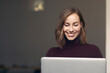 © Martin Villadsen - Beautiful business woman and student girl working on her laptop while smiling to the computer and looking gorgeous. Brunette hair and a big white smile. Concept: professional female employee at work.