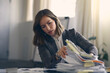 © Martin Villadsen - Busy business woman looking through a large pile of paperwork on her office desk, being stressed.