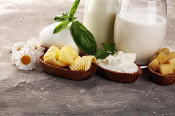 Wall Mural - milk products. tasty healthy dairy products on a table on. mozzarella in a bowl, cottage cheese bowl, butter swirls, glass bottle