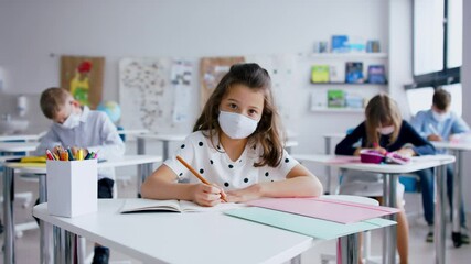 Poster - Child with face mask back at school after covid-19 quarantine and lockdown, writing.