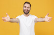 © ViDi Studio - Cheerful young bearded man guy in white casual t-shirt posing isolated on yellow background studio portrait. People emotions lifestyle concept. Mock up copy space. Standing with outstretched hands.