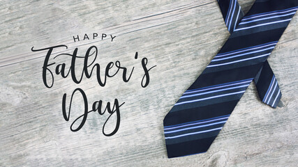 Happy Father's Day Greeting Card Calligraphy Text with Striped Neck Tie Over Light Wood Background