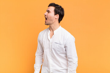 Wall Mural - young handsome man screaming furiously, shouting aggressively, looking stressed and angry