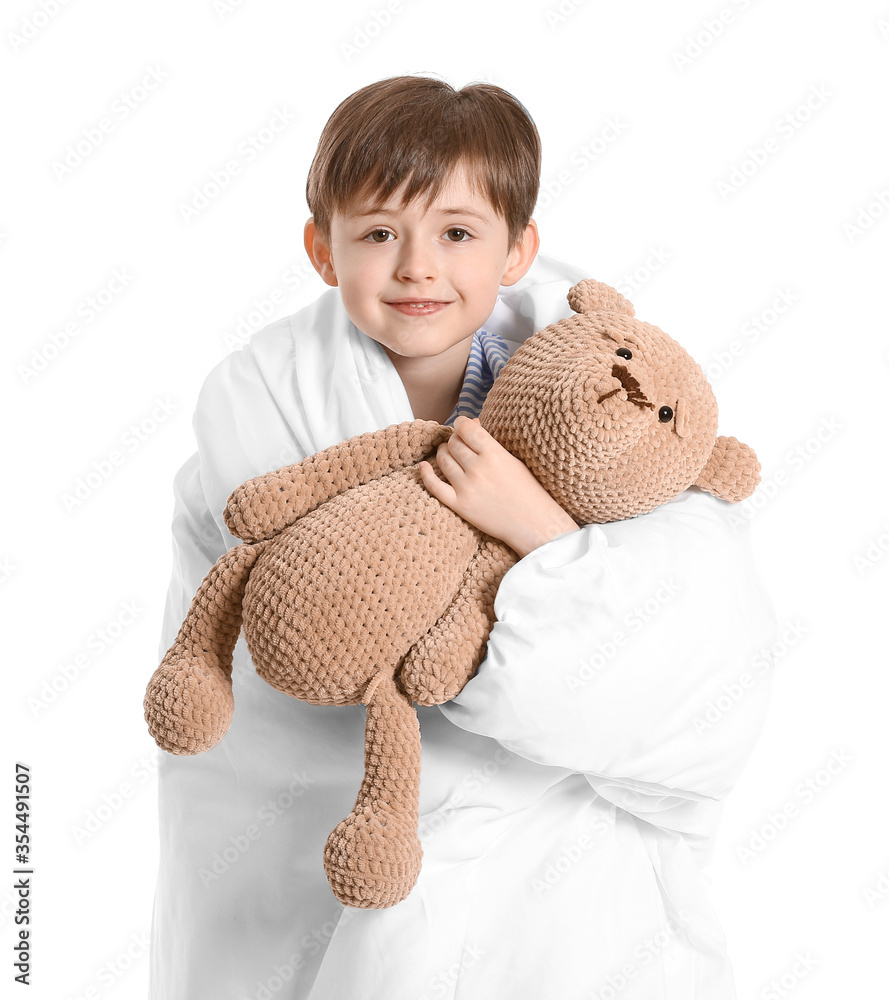 Little boy wrapped in blanket and with toy on white background
