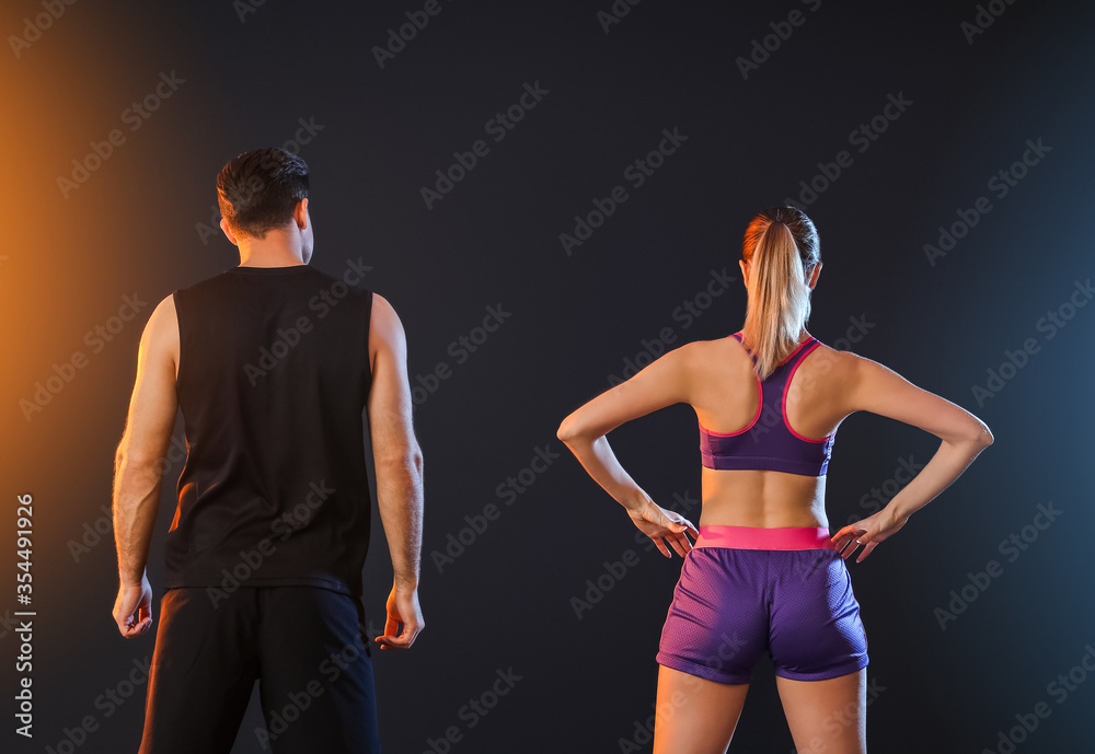 Sporty young couple on dark background