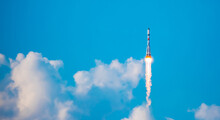 Take-off Of A Real Launch Vehicle From A Spaceport. A Rocket Takes Off Into The Sky Against A Background Of Clouds. Startup Concept, Power Of Science And Technology.