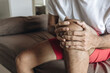 © anut21ng Stock - Close up young man suffering from knee pain in bedroom