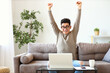 Excited freelancer celebrating success on couch.