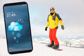 Wall Mural - male snowboarder on snowy hill and smartphone with open weather forecast app