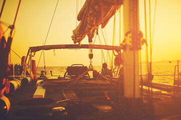 Wall Mural - Sailor steering sailing boat with a rudder in dawn / twilight time on tje open sea.