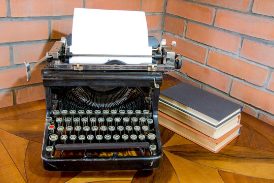 Old black typewriter with paper worth on the painted table