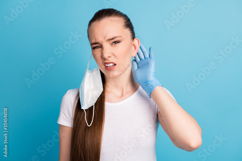 Closeup photo of beautiful displeased lady bad mood hate use facial respirators sensitive skin touch ear ache wear latex gloves protect face mask white t-shirt isolated blue color background