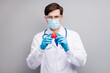 © deagreez - Photo of handsome doc guy professional experienced virologist hold covid bacteria vaccine research wear facial protective mask medical uniform coat tie stethoscope isolated grey background