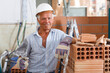 © JackF - Happy bricklayer near brick stack