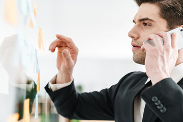 Sticker - Image of concentrated businessman talking on cellphone while working