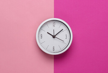 Wall Mural - White clock on pink pastel background. Minimalistic studio shot. Top view