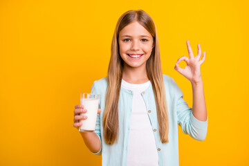 Sticker - Photo of beautiful little blond lady hold arm fresh milk glass show okey symbol advising drink dairy products every morning healthy wear casual blue shirt isolated yellow color background