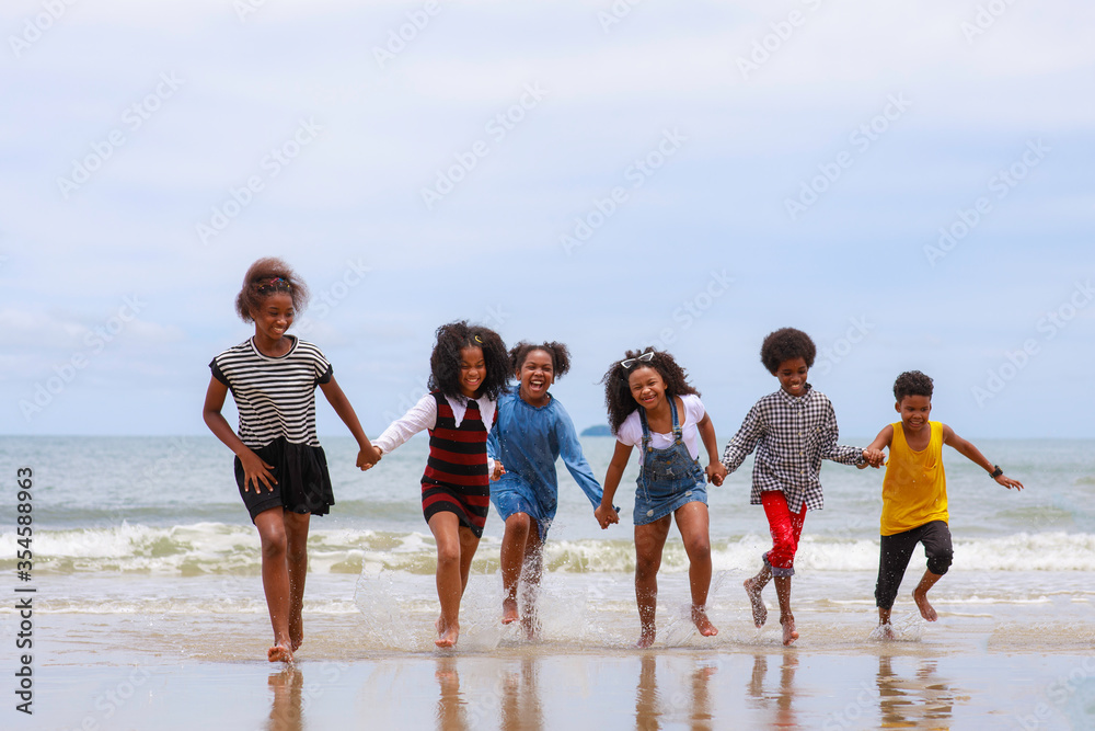Group of African kid playing joyful on the beach together after ...