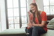 © LIGHTFIELD STUDIOS - cheerful girl in party cap holding glass of red wine and talking on smartphone at home