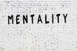 Word mentality painted on white brick wall
