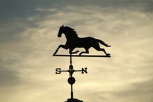 Closeup Shot Of A Horse Weather Vane Set Against A Sunset Sky